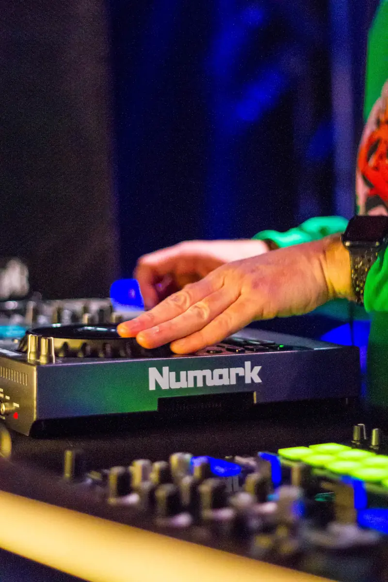 DJ hands on the decks under blue light