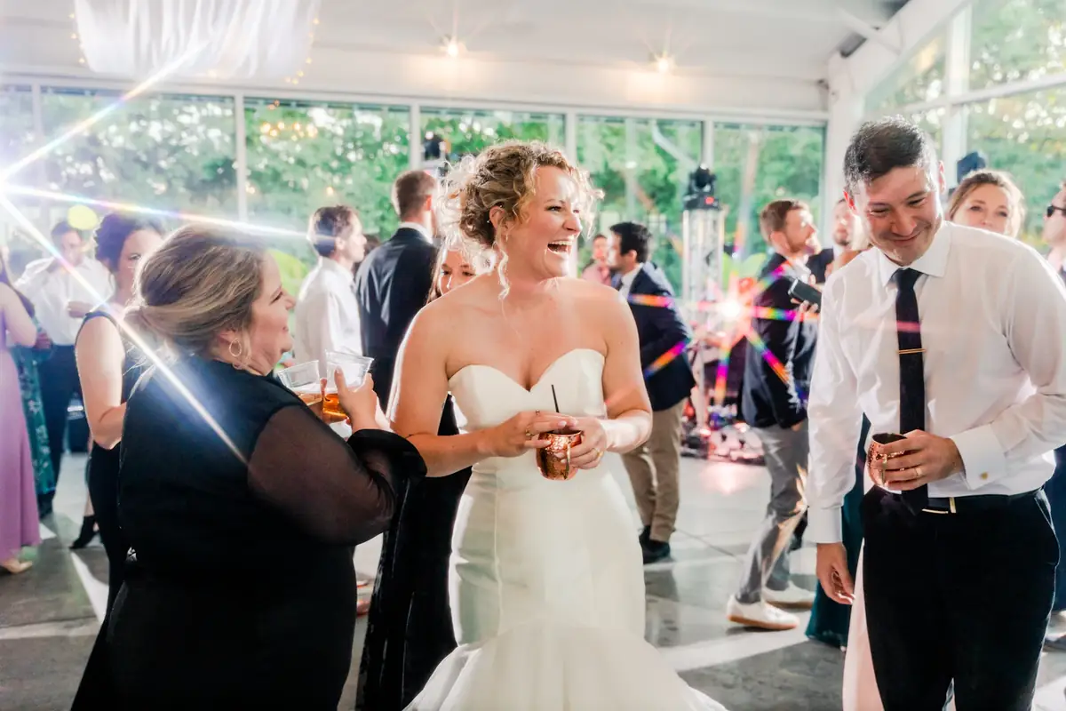 Couple laughing with guests on the dance floor